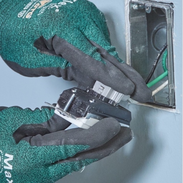 Contractor installing a PlugTail device into a light blue wall.