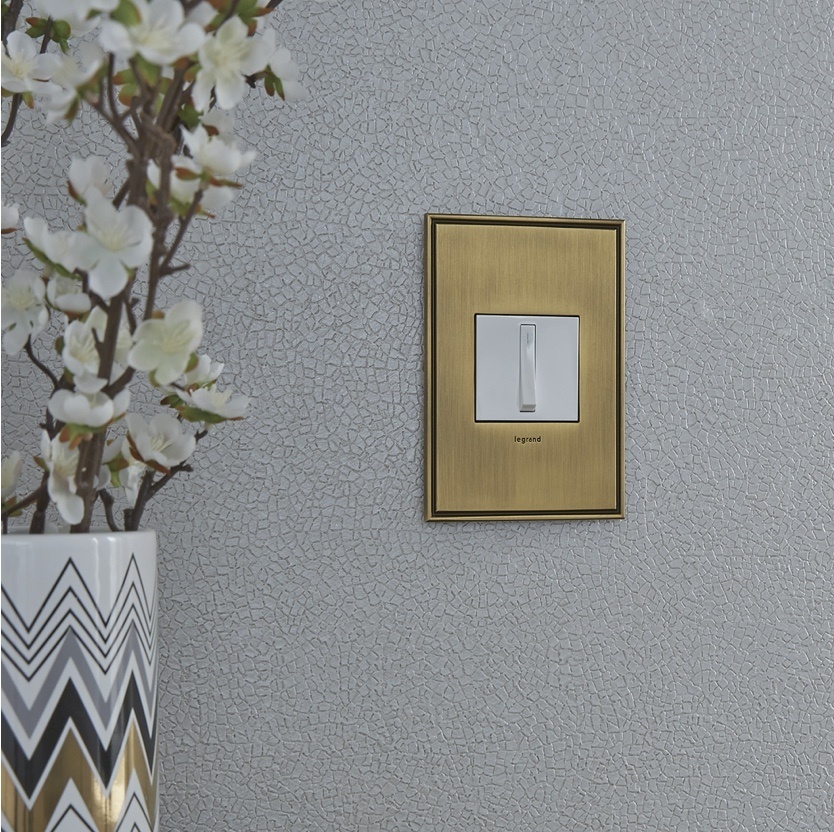 adorne Collection designer light switch and wall plate next to vase of flowers