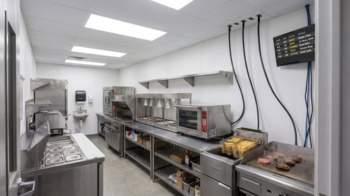 Commercial kitchen with ceiling-mounted multi service electrical ceiling panels supplying overhead power connections.
