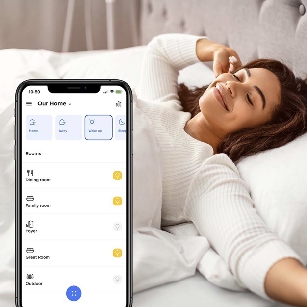 woman waking up refreshed from bed with smart lighting app close up shot