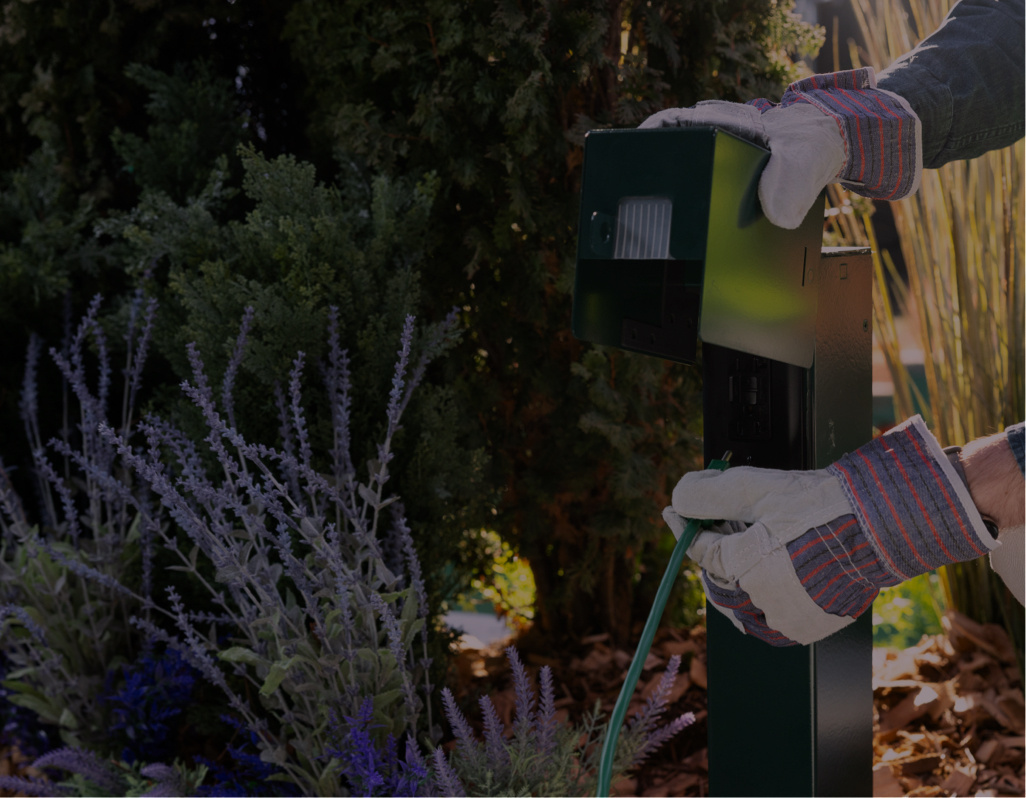Hand placing powering device into greenery