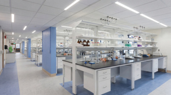 Workspace with ceiling-mounted multi service electrical ceiling panels above work benches.