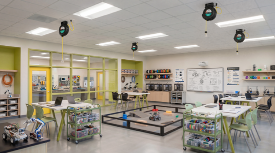 800 series cable reel mounted on the ceiling in a modern classroom, with a retractable yellow power cord extending down to provide convenient overhead power for workstations and equipment.